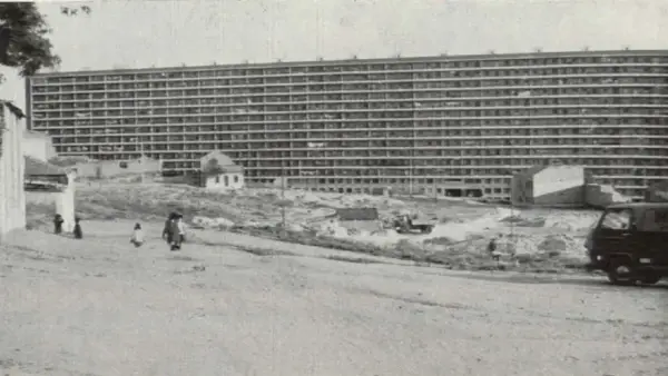 Edificio masivo de apartamentos en construcción, con obreros y vehículos en el sitio. Imagina cómo se veía cuando se inventó el cemento.